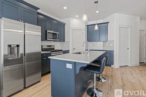 Lehi apartment for rent - A kitchen with a blue island and stainless steel appliances.