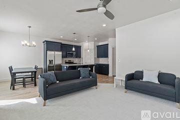 Lehi apartment for rent - A modern living room with a grey sofa and a dining table.