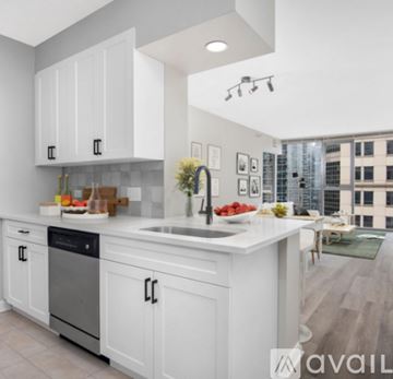 Chicago condo for rent - A modern kitchen with white cabinets and a large island.
