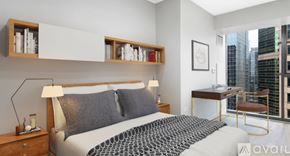 Chicago condo for rent - A bedroom with a large bed and a desk with a chair.