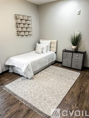 Rolla apartment for rent - A bedroom with a white bed and a wooden floor.