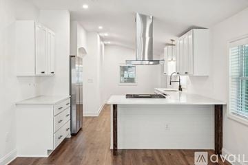 North Charleston house for rent - A modern kitchen with white cabinets and a wooden island.