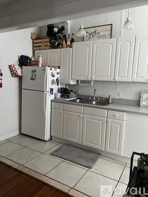 Tampa apartment for rent - A white kitchen with a fridge and cabinets.