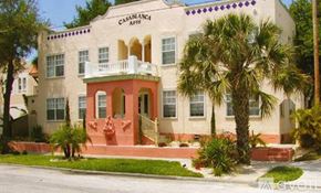 Tampa apartment for rent - A white building with a balcony and a red door.
