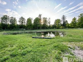 Thompsonville house for rent - A serene landscape with a pond, trees, and a clear sky.
