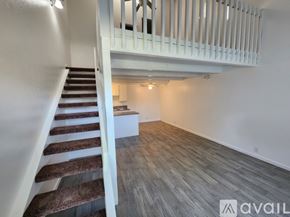 Bakersfield apartment for rent - A staircase with a carpeted runner leads up to a second floor landing with a white railing.