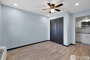 Houston apartment for rent - A room with a ceiling fan and a door leading to a kitchen.