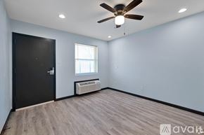 Houston apartment for rent - A room with a ceiling fan and a window with blinds.