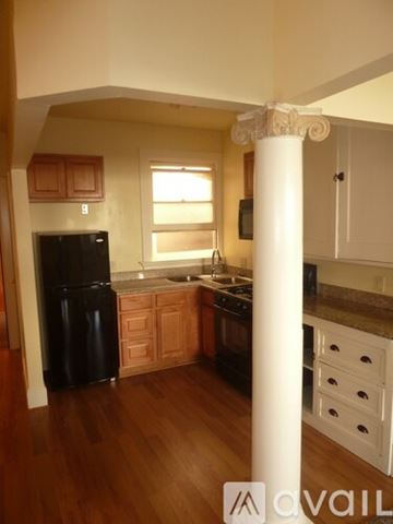 Vallejo apartment for rent - A kitchen with wooden floors and a black refrigerator.