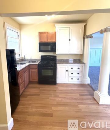 Vallejo apartment for rent - A kitchen with wooden cabinets and black appliances.
