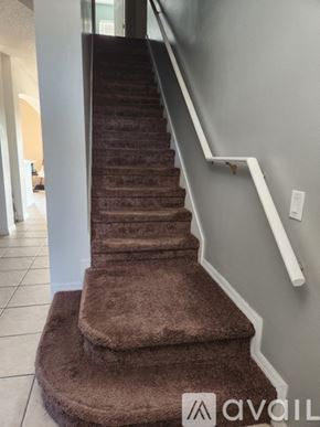 Orlando house for rent - A staircase with a brown carpeted runner and white handrails.