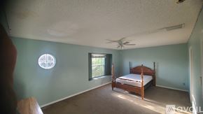 Orlando house for rent - A bedroom with a bed, window, and ceiling fan.