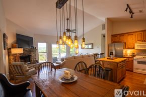 Clayton house for rent - A modern kitchen with wooden cabinets and a dining table set for two.