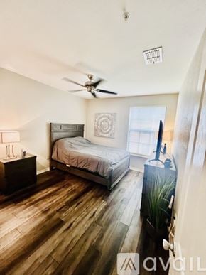 Sarasota apartment for rent - A bedroom with a bed, dresser, and ceiling fan.