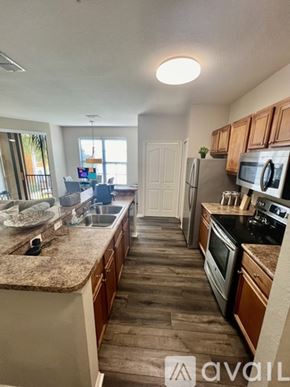 Sarasota apartment for rent - A kitchen with wooden cabinets and a granite countertop.