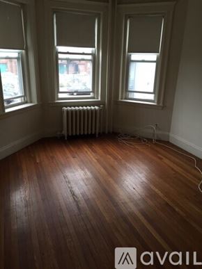 Boston apartment for rent - A room with wooden floors and two windows.