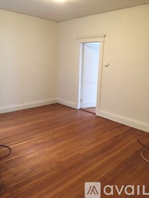 Boston apartment for rent - A room with wooden flooring and a doorway leading to another room.