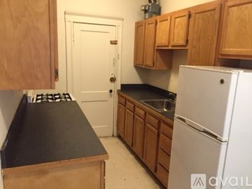 Boston apartment for rent - A kitchen with wooden cabinets and a black countertop.