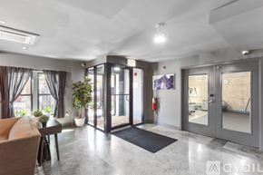 Chicago apartment for rent - A modern living room with a sofa, a table, a plant, and a fire extinguisher on the wall.