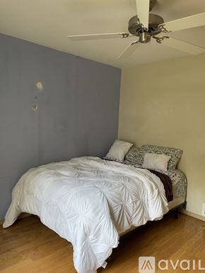 Jacksonville apartment for rent - A bedroom with a bed and a ceiling fan.