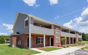 Greenville apartment for rent - A modern building with a red brick facade and a white roof.