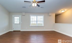 Greenville apartment for rent - A spacious room with a ceiling fan and wooden flooring.