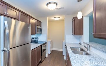 Greenville apartment for rent - A kitchen with a stainless steel refrigerator and wooden cabinets.