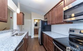 Greenville apartment for rent - A kitchen with brown cabinets and a granite countertop.