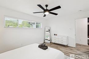Irving house for rent - A bedroom with a white bed and a ceiling fan.