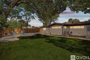 Irving house for rent - A backyard with a fence, lawn, and trees.