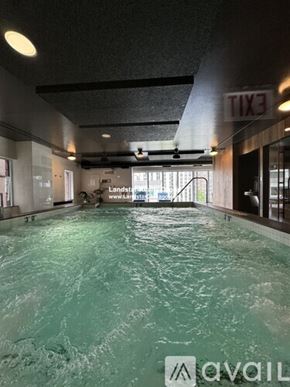 Chicago apartment for rent - A large indoor swimming pool with a textured ceiling and a glass wall on the right side.