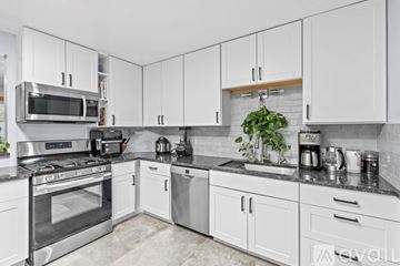 Albuquerque apartment for rent - A kitchen with white cabinets and a black countertop.