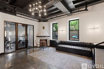 Chicago apartment for rent - A living room with a black couch and a fireplace.