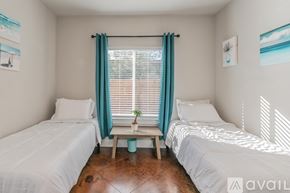 Fort Worth house for rent - A bedroom with two beds and a window with a plant on the table.