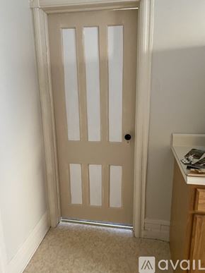 Glens Falls apartment for rent - A white door with a black handle is in a room with a carpeted floor.