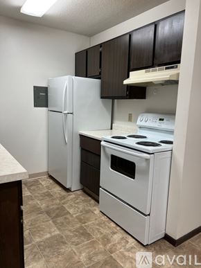 North Mankato apartment for rent - A kitchen with a white fridge, white stove, and brown cabinets.