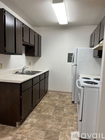 North Mankato apartment for rent - A kitchen with brown cabinets and a white stove.