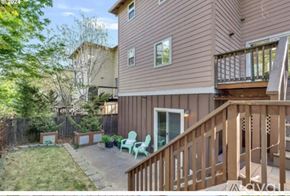 Hood River house for rent - A brown house with a green chair and a wooden deck.