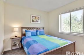 Hood River house for rent - A bedroom with a bed, nightstand, and window.