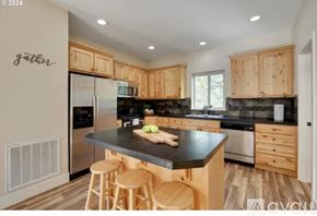 Hood River house for rent - A kitchen with wooden cabinets and a black countertop.