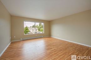 Seattle apartment for rent - Empty room with wooden flooring and a large window.
