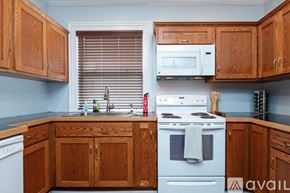 Oneonta apartment for rent - A kitchen with wooden cabinets and a white stove top oven.
