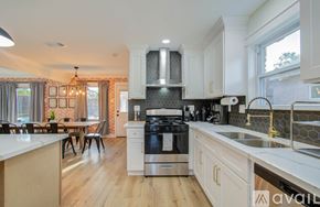 Houston house for rent - A modern kitchen with a stove top oven and a dining table with chairs.