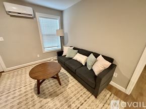 Waynesville apartment for rent - A living room with a grey couch, a wooden table, and a carpet.