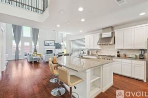 Irving house for rent - A kitchen with white cabinets and a wooden floor.