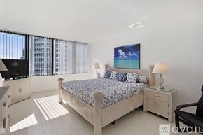 Hollywood condo for rent - A bedroom with a large bed and a painting of a beach scene on the wall.