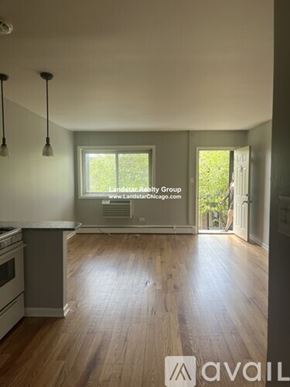 Morton Grove apartment for rent - A kitchen with wooden floors and a window that says Landstar Realty Group.