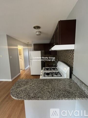 Morton Grove apartment for rent - A kitchen with a granite countertop and a stove top oven.