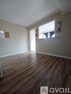 Knoxville condo for rent - A room with wooden flooring and a window with blinds.