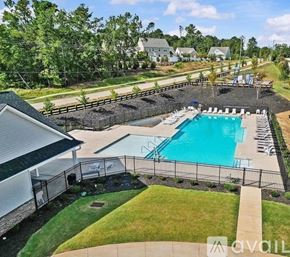 Greenville townhouse for rent - A pool surrounded by a black fence with a house in the background.